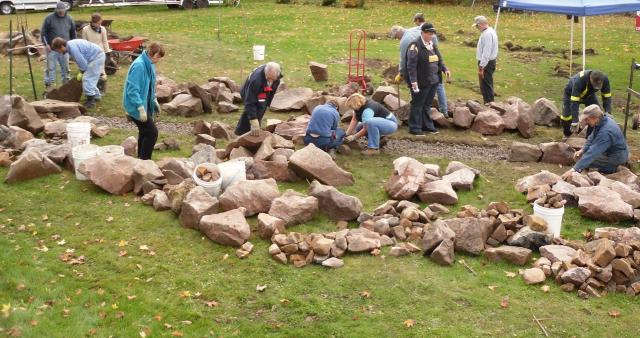 Fishing through the whale-size chunks of rocks to begin building a whale of a wall in 'Rockport', Ontario
